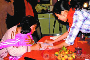 農(nóng)秀梅抱著孩子簽名領(lǐng)取200元路費(fèi)