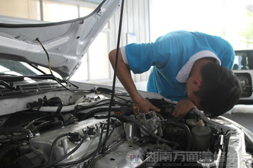 萬通汽修學生對實訓設備進行檢修中