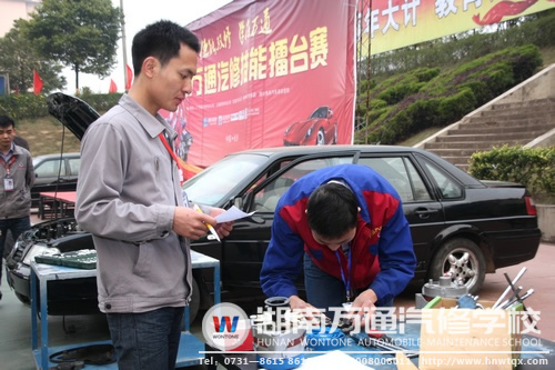 汽修學(xué)校評委老師在一旁打分