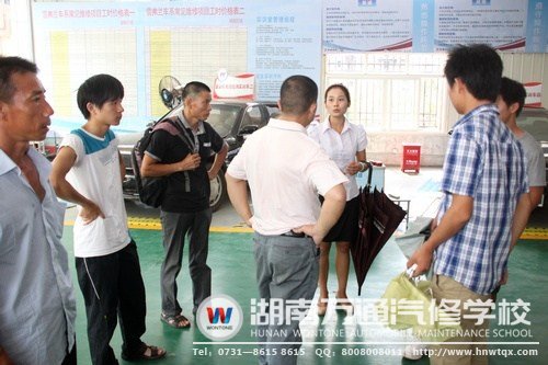 在高級轎車實(shí)訓(xùn)中心，咨詢老師給學(xué)生及其家人講述要學(xué)習(xí)的課程